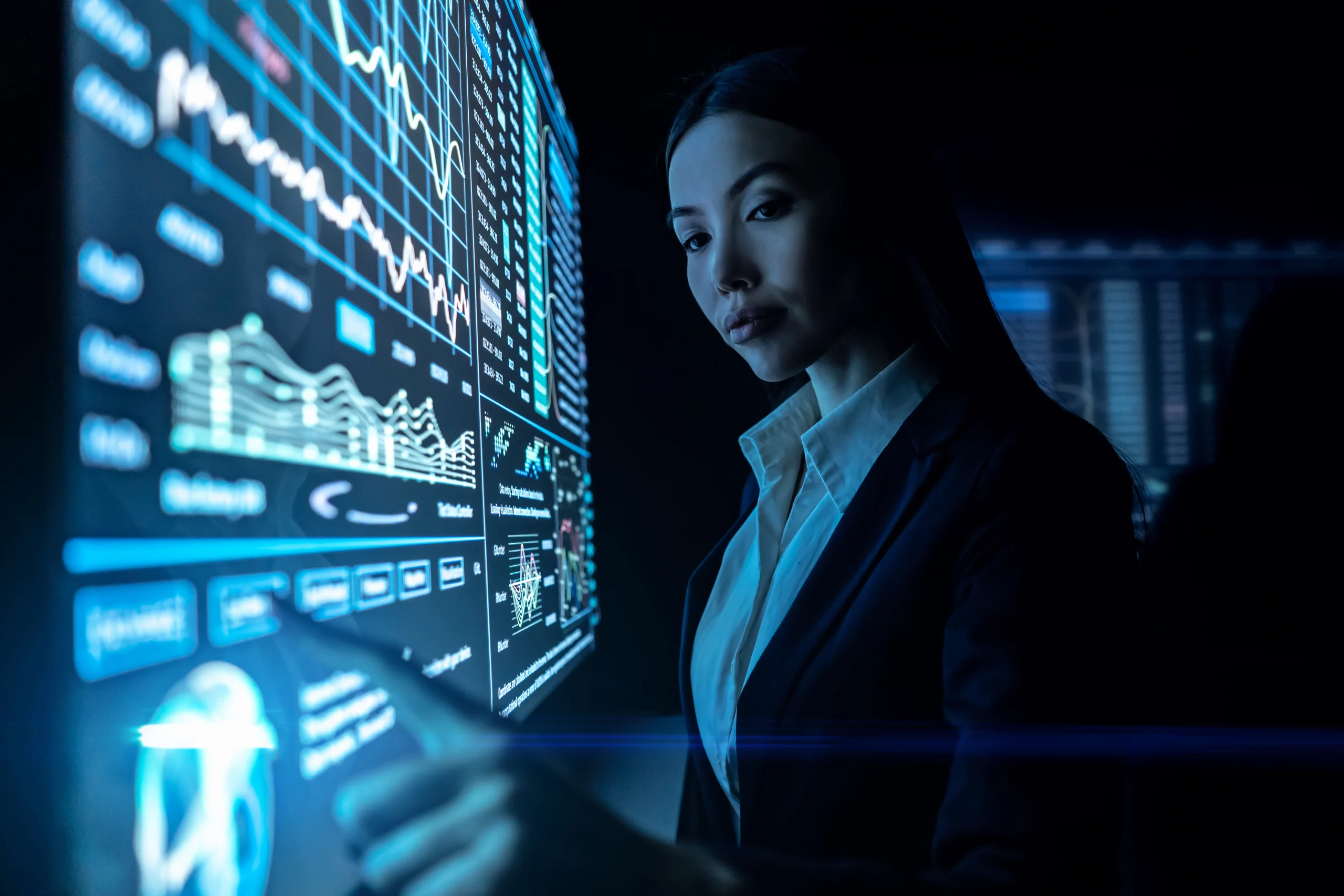 Woman analyzing data on large digital screen.