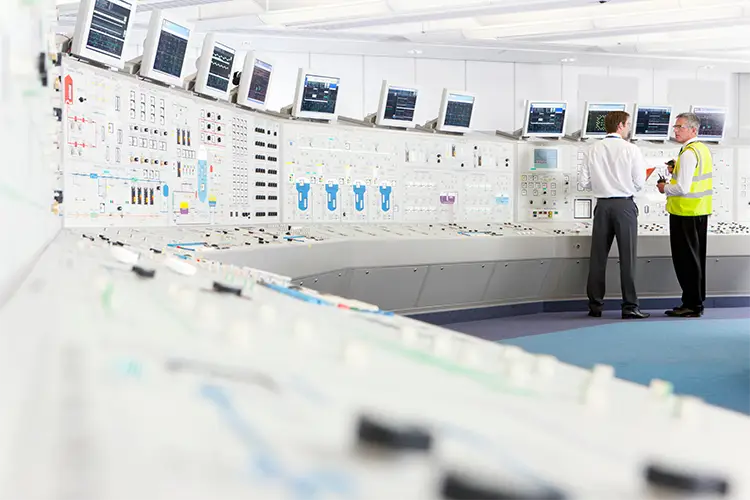 Engineers monitoring systems in industrial control room